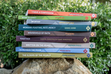 Load image into Gallery viewer, Stack of books from Grassmarket Press on a rock with a green foliage background